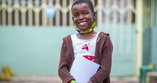 A closeup shot of a black male child holding a notebook - education concept